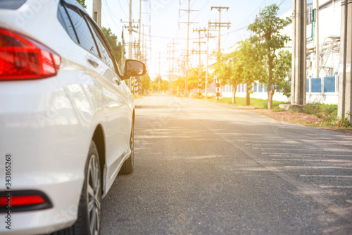 White cars parked on the roadside, with natural backgrounds and with bright sunlight.