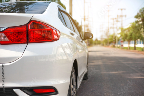 White cars parked on the roadside, with natural backgrounds and with bright sunlight.