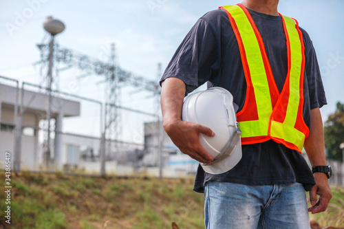 Close-up Engineering holds white safety hats on hight Electric volteage background