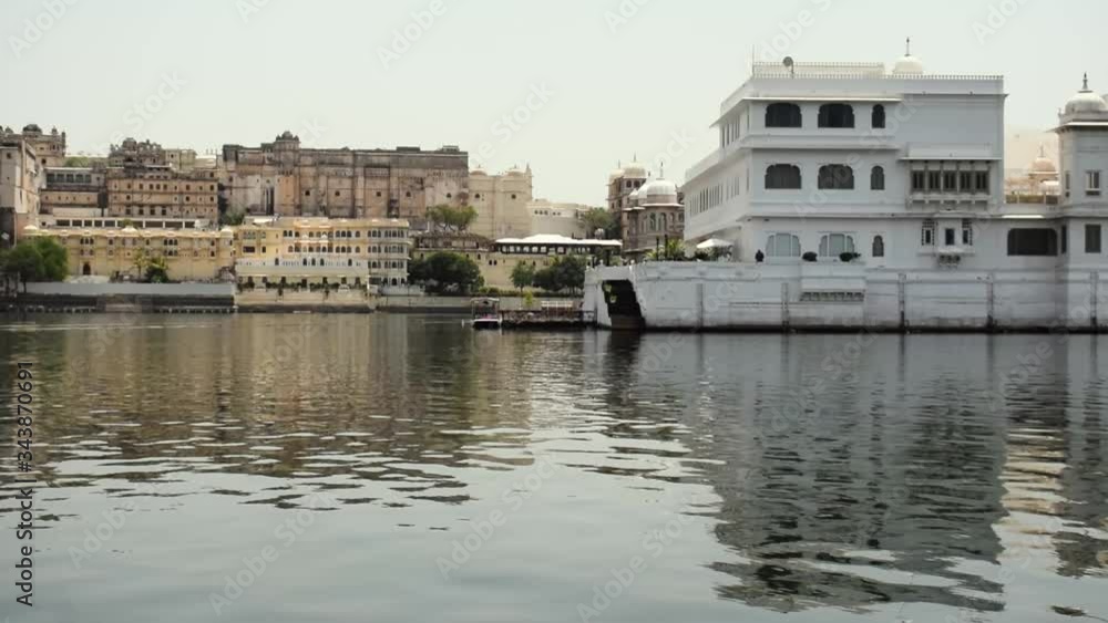 Lake Pichola and buildings in Udaipur, Rajasthan, India. Video made from a moving boat. The video shows houses on the shore and reflection in water. Lake Pichola and buildings in Udaipur, Rajasthan, India. Video made from a moving boat. The video shows houses on the shore and reflection in water.