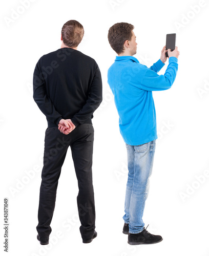 Back view of two man in sweater with mobile phone.