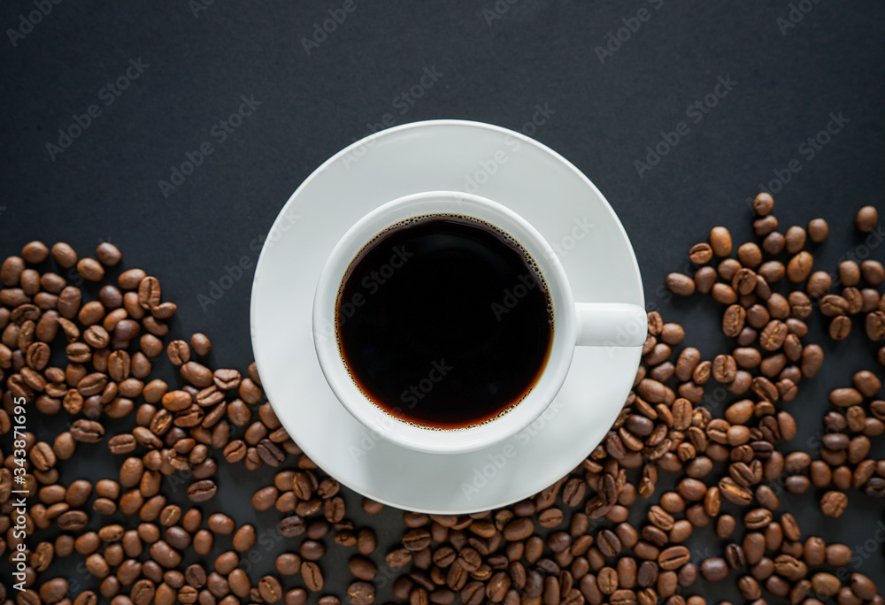 Cup of black coffee on black background with roasted coffee beans Cup of black coffee on black background with roasted coffee beans