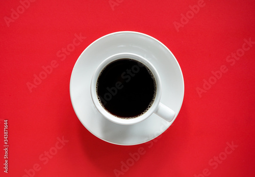 Cup of black coffee on abstract red and brown background with copy space