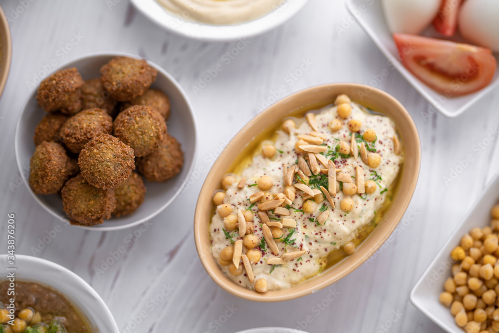 arab breakfast with hummus and falafel and fattah and foul on white wooden table Jordanian food 