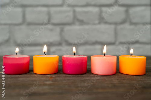 Φωτογραφία five red an orange tealight candles in a row