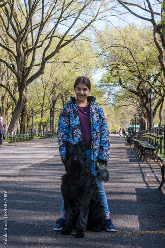 Obraz na płótnie Lovely young girl training a Giant Schnauzer in Central Park w salonie