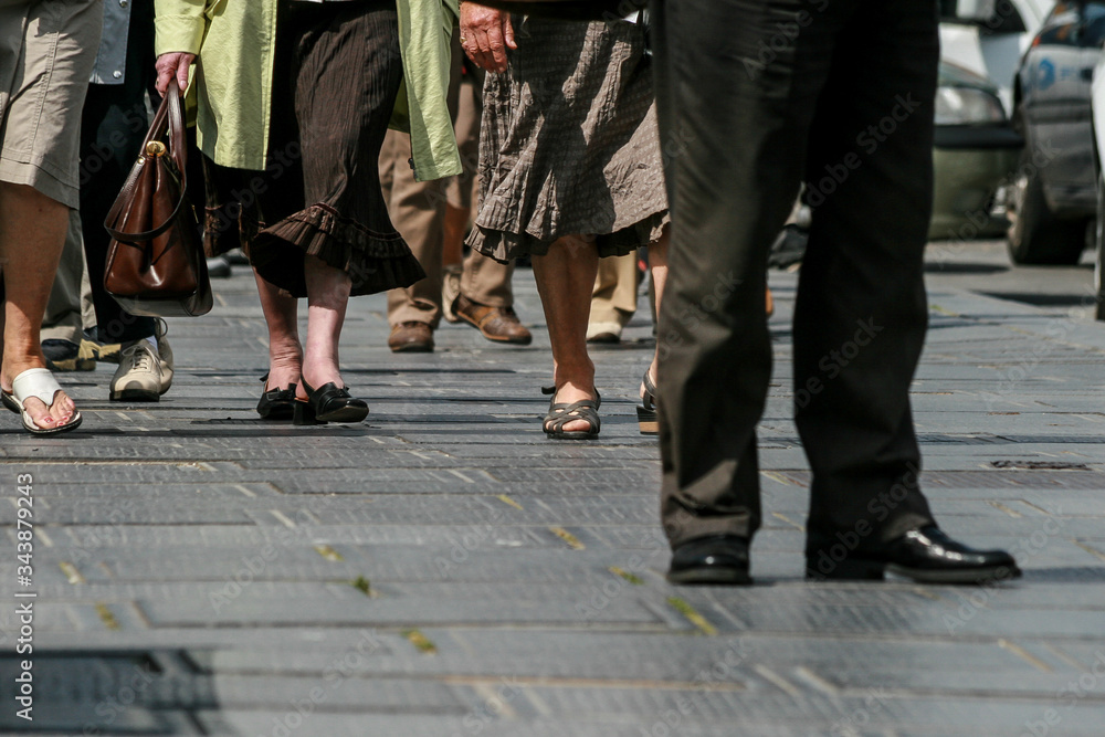 People feet's walking on a dark pavement People feet's walking on a dark pavement