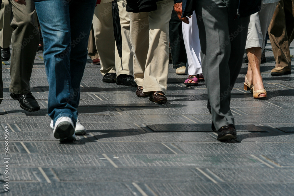 People feet walking on a dark pavement People feet walking on a dark pavement