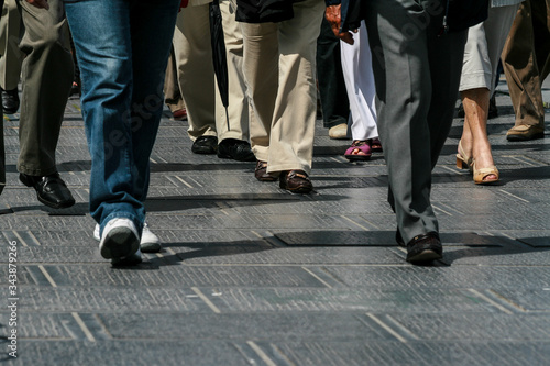 People feet walking on a dark pavement