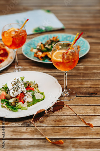 Table with food and drinks on the restaurant terrace on a summer day. Aperol spritz in a summer