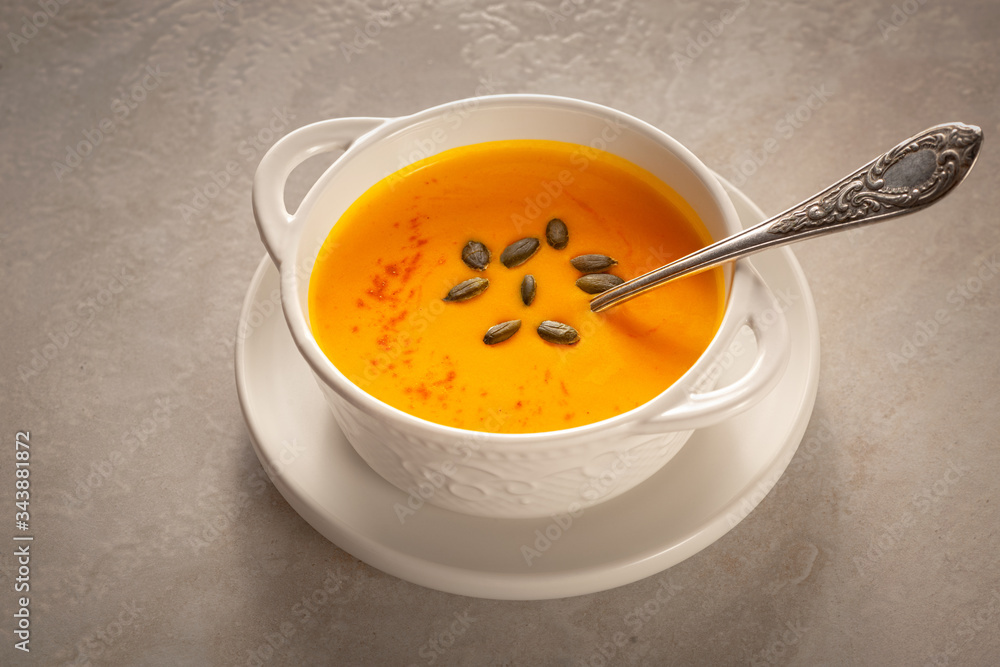 Bowl of tasty pumpkin soup and space for text on gray table, top view Bowl of tasty pumpkin soup and space for text on gray table, top view