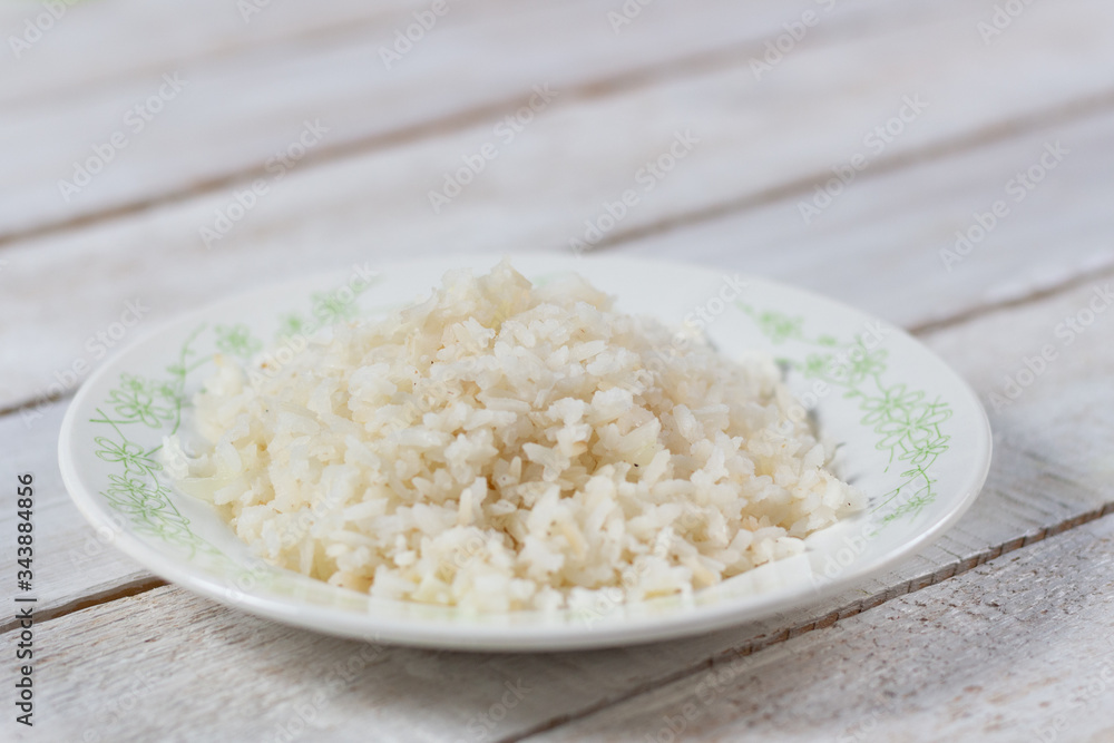 White boiled rice on plate on wooden background White boiled rice on plate on wooden background