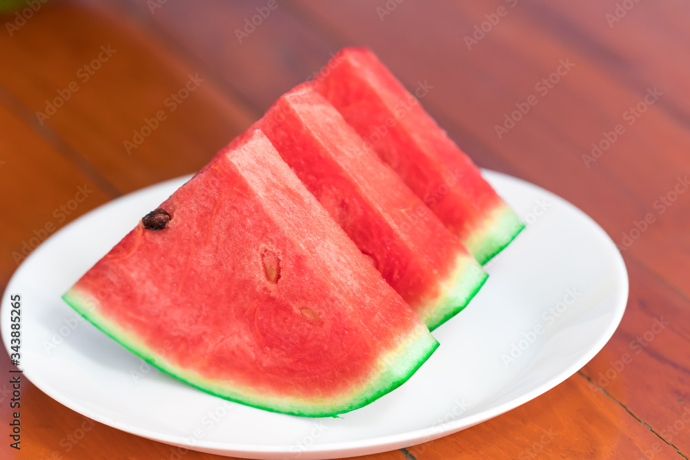watermelon in dish white on wood flooring. close up
