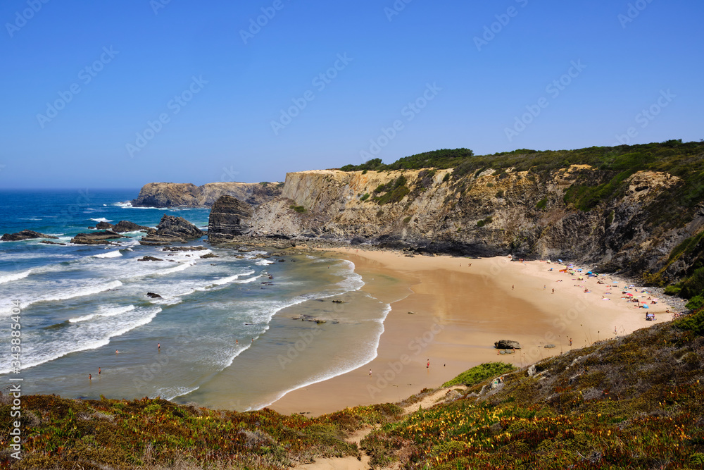 Beach and cliff at Praia do Carvalhal. Solo Backpacker Trekking on the Rota Vicentina and Fishermen's Trail in Alentejo, Portugal. Walking between cliff, ocean, nature and beach. Beach and cliff at Praia do Carvalhal. Solo Backpacker Trekking on the Rota Vicentina and Fishermen's Trail in Alentejo, Portugal. Walking between cliff, ocean, nature and beach.