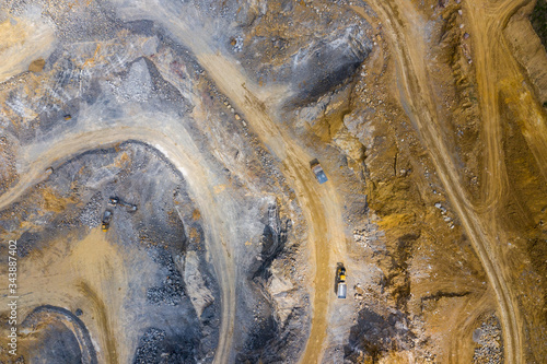 Mining from above. Industrial terraces on open pit mineral mine. Aerial view of opencast mining. Dolomite Mine Excavation. Extractive industry. Giant excavator machinery.