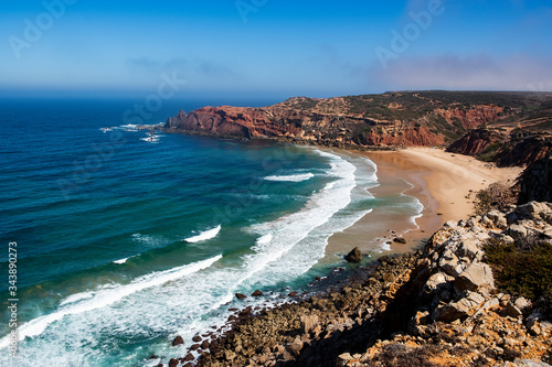 Cliff and Praia do Telheiro. Solo Backpacker Trekking on the Rota Vicentina and Fishermen's Trail in Algarve, Portugal. Walking between  ocean, nature and beach. photo
