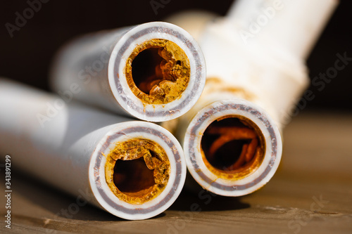 Картината върху платно Old broken sludge plumbing polypropylene pipes with red rust and limescale
