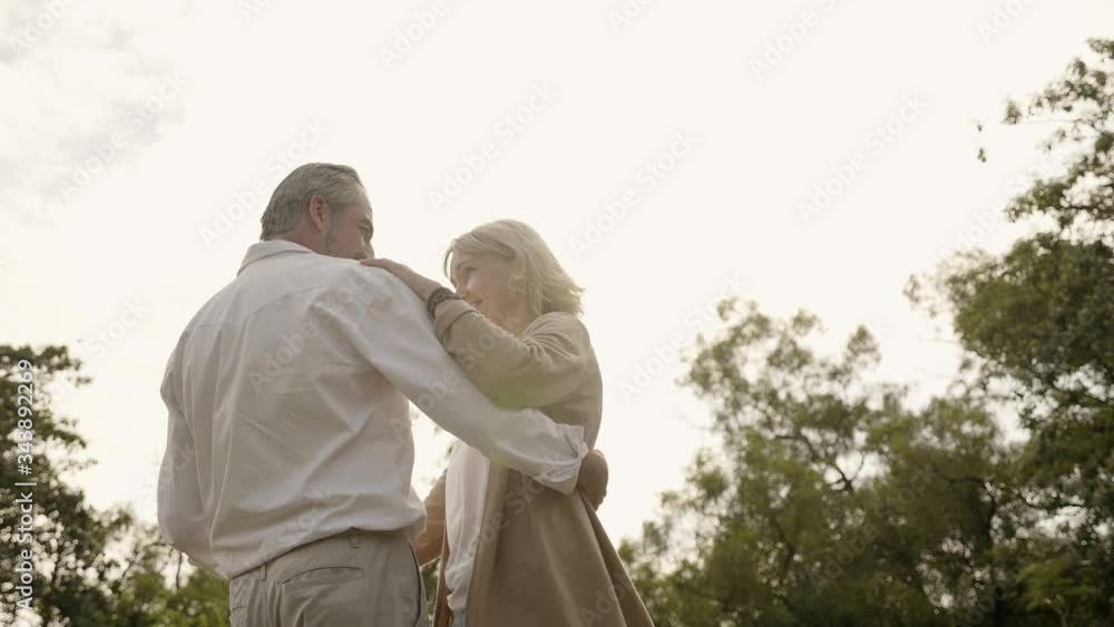 Senior Caucasian couple dancing in park. Happy smile, feel relax with nature in the morning. Or in the evening. Is a family party. Healthcare lifestyle retirement married grandparents wellbeing Senior Caucasian couple dancing in park. Happy smile, feel relax with nature in the morning. Or in the evening. Is a family party. Healthcare lifestyle retirement married grandparents wellbeing