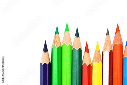 Some different colored wooden pencil crayons placed in a row in front of a white background