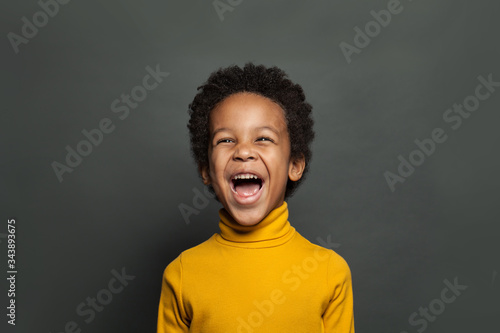 Happy black child boy laughing on black background