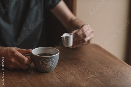 gray cup of coffee and a cup of milk on a wooden table