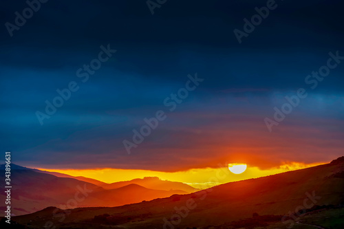Sun setting over Silhouetted Mountains, Clouds  © Mark