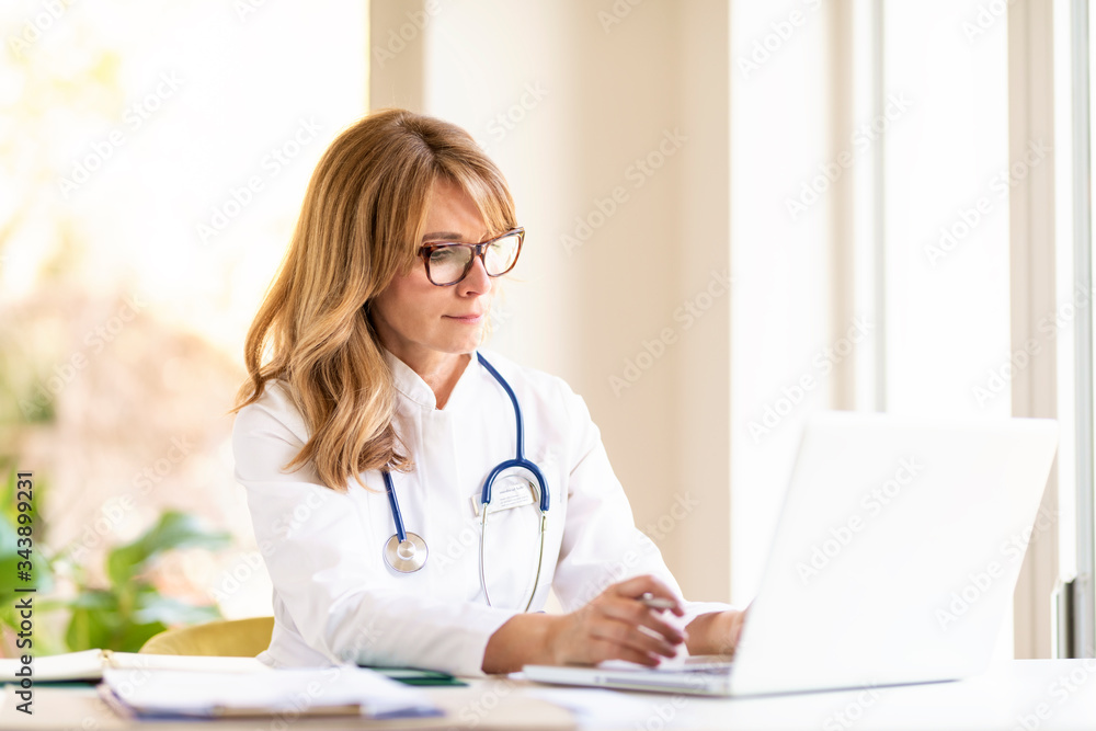 Female doctor using notebook while working Female doctor using notebook while working