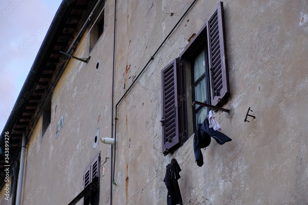 Wet trekking clothes, put to dry after a day of walking in the rainSolo Backpacker Trekking on the Via Francigena from Lucca to Siena. Walking between nature, history, churches, Wet trekking clothes, put to dry after a day of walking in the rainSolo Backpacker Trekking on the Via Francigena from Lucca to Siena. Walking between nature, history, churches,