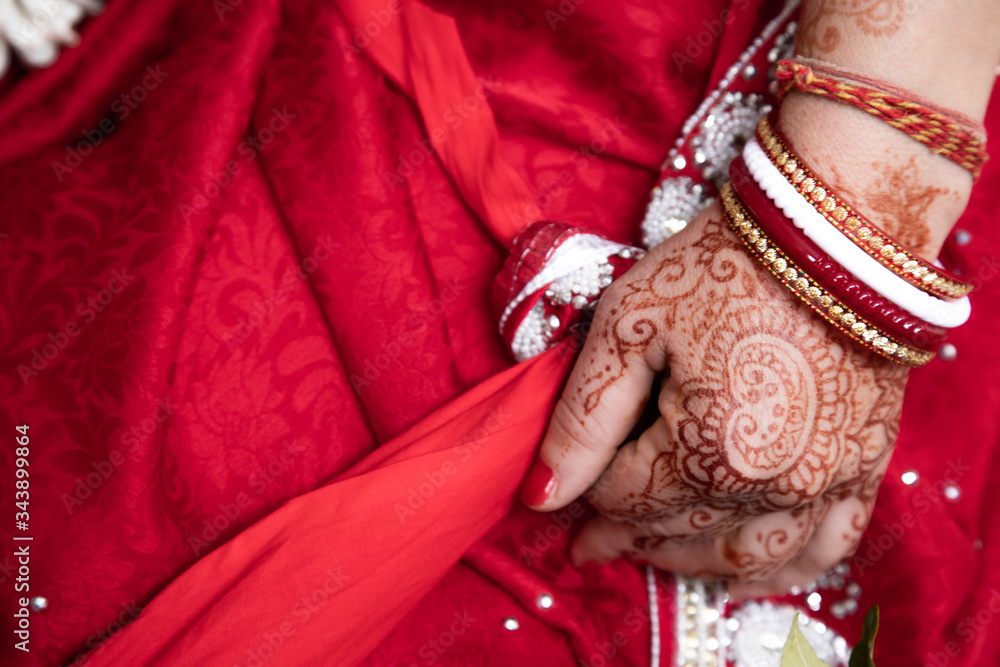 bride in a red Sari. Beautiful traditional Indian wedding ceremony. bride's hand is decorated with mehendi and bracelets. Hindu wedding. indian engagement. Hindu the Vedic Yagya ceremony. vivah Yajna.