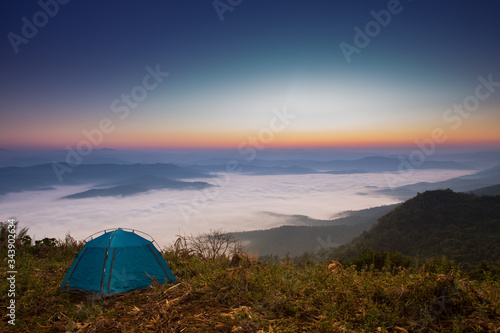 Majestic sunset with Camping tent in the mountains landscape. Overcast sky. © yufagu