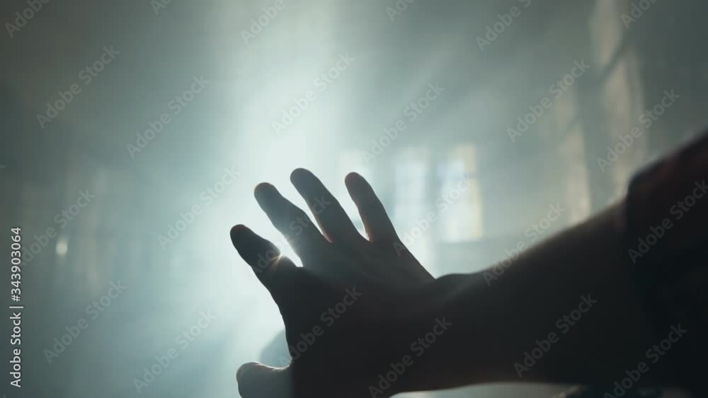 Silhouette of a Hand against a sunrays. Sunlight shining between fingers Silhouette of a Hand against a sunrays. Sunlight shining between fingers