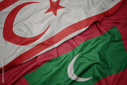 waving colorful flag of maldives and national flag of northern cyprus. photo