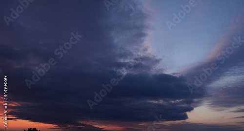 Evening. Terrible, cloudy, sky. Panoramic photographic image, lighting of the sky above the horizon at sunset.