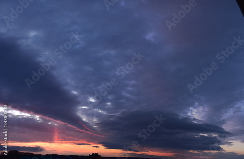 Evening. Terrible, cloudy, sky. Panoramic photographic image, lighting of the sky above the horizon at sunset.