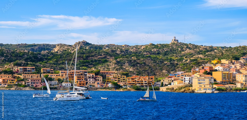 Panoramic view of La Maddalena old town quarter in Sardinia, Italy with port at the Tyrrhenian Sea coastline and island mountains interior in background