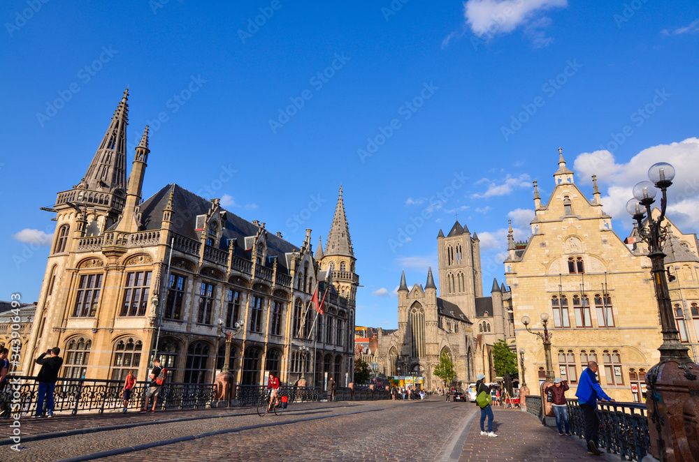 Ghent, Belgium, August 2019. In the historic center, one of the most beautiful views of the city: the bridge of St Michael. in the direction of the church of San Nicola. People stop to enjoy the view.