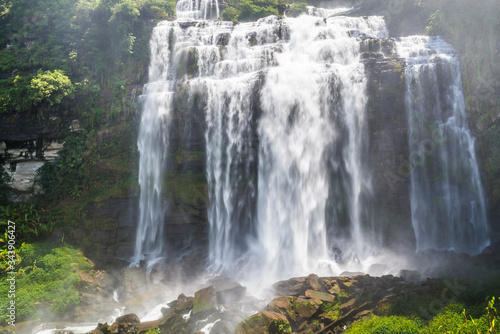 Flowing water of large and high waterfall on mountain cliff in the tropical rain forest. Beautiful nature waterfall in Bolaven Plateau, southern Laos, Tad kamud waterfall © cattyphoto