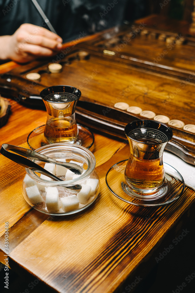 Men are playing backgammon in a cafe, drinking tea, close up of a board game