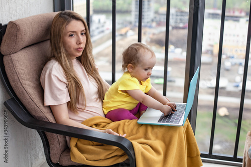 woman working on a laptop at home. baby disturb and trying to typing on keyboard © Ekaterina Shvaygert