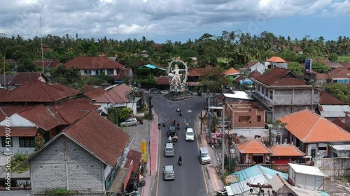 flying next to the Pura Dalem Temple Puri Peliatan-Ubud located in the center of Ubud in the tropical jungle along a busy road cars scooters