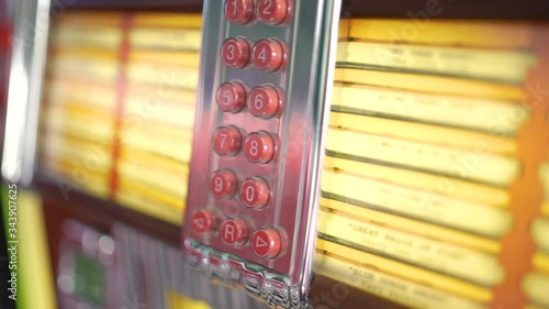 The inside parts and red number buttons with songs of a retro and vintage american fifties juke box in close up with a shallow depth of field. photo