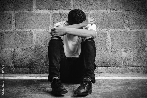 Obraz na płótnie decepción de un hombre sentado en el piso tapándose la cara de tristeza