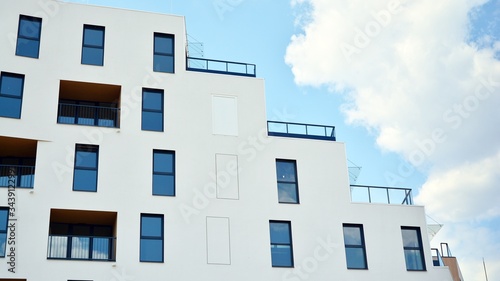 Contemporary residential building exterior in the daylight. Modern apartment buildings on a sunny day with a blue sky. Facade of a modern apartment building