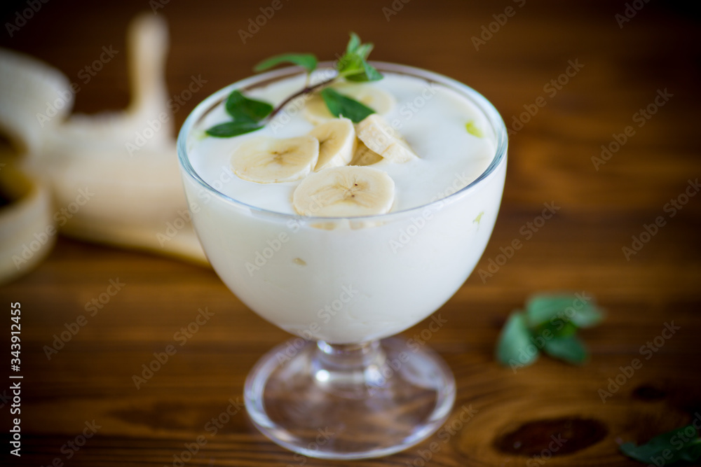 Homemade sweet yogurt with slices of ripe banana in a glass bowl Homemade sweet yogurt with slices of ripe banana in a glass bowl