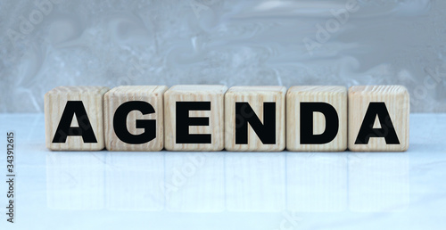 concept word AGENDA on wooden cubes on a beautiful gray background