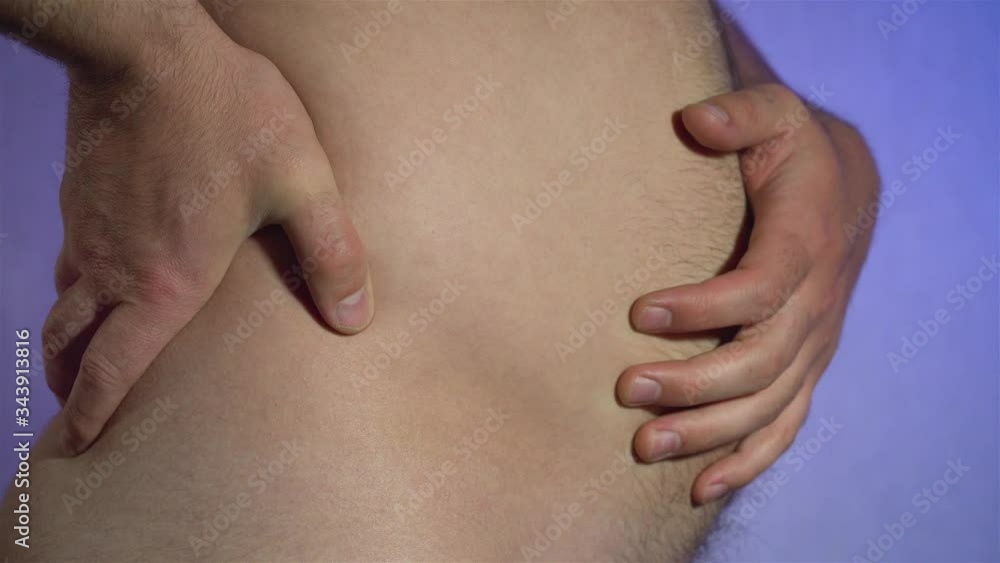 Man slaps his large hairy belly with initial stage of obesity using palm of hand. Unhealthy lifestyle and nutrition Man slaps his large hairy belly with initial stage of obesity using palm of hand. Unhealthy lifestyle and nutrition