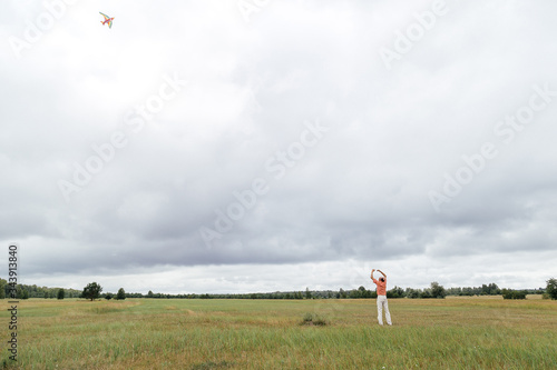 Man fly a kite on the field. Rural area, Russia.