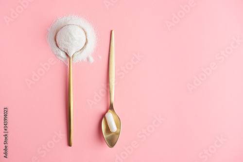 Collagen powder and pills on pink background close-up. Extra protein intake. Natural beauty and health supplement for skin, bones, joints and gut. Flatlay, top view. Copy space text.