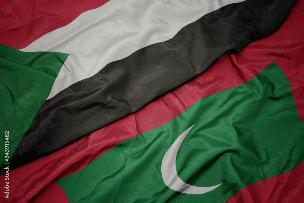 waving colorful flag of maldives and national flag of sudan.