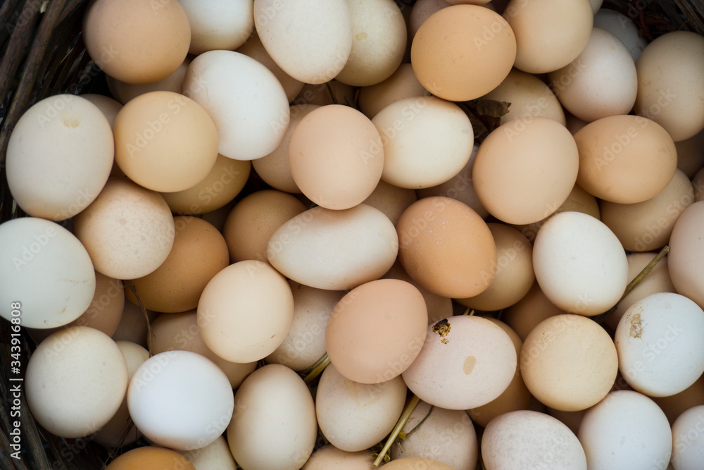 Eggs with shell on a wicker basket. Eggs are shown for sale at a village bazaar. Calorie intake food for bodybuilding / gym sport.